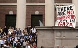 Un manifestant brandit une pancarte sur laquelle on peut lire "Il n'y a plus d'universités à Gaza" lors de la cérémonie de remise des diplômes, le 29 mai 2025, à Cambridge, dans le Massachusetts. (Crédit : Libby O'Neill / Getty Images via AFP)