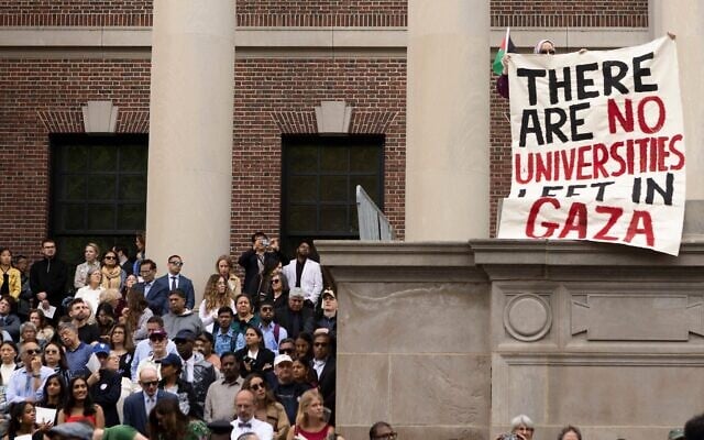 Un manifestant brandit une pancarte sur laquelle on peut lire "Il n'y a plus d'universités à Gaza" lors de la cérémonie de remise des diplômes, le 29 mai 2025, à Cambridge, dans le Massachusetts. (Crédit : Libby O'Neill / Getty Images via AFP)