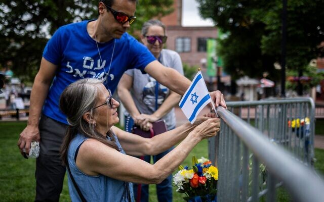 Des personnes déposent des fleurs et un drapeau israélien sur le lieu d'une attaque meurtrière devant le palais de justice du comté de Boulder, le 2 juin 2025, à Boulder, dans le Colorado. (Crédit : Chet Strange / Getty Images via AFP)