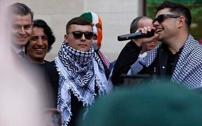 Le chanteur du groupe de rap irlandais Kneecap, Liam O'Hanna au centre, qui se produit sous le nom de scène Mo Chara, devant le tribunal de première instance de Westminster, à Londres, le 18 juin 2025, après avoir été accusé de soutien au Hezbollah. (BENJAMIN CREMEL / AFP)