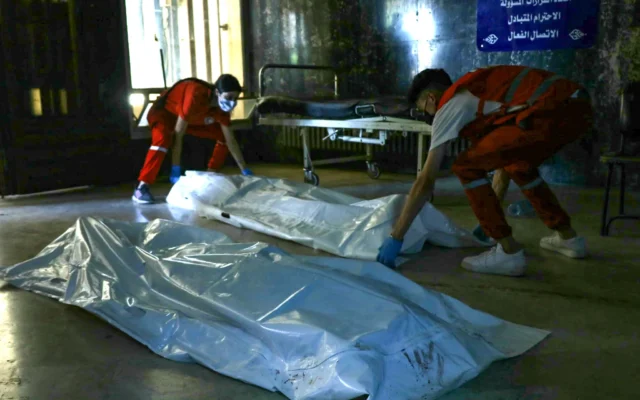 Contenu sensible / Des secouristes du Croissant-Rouge déposent les corps des victimes des récents affrontements entre des combattants druzes locaux et des tribus bédouines, à l'intérieur d'un hôpital de la ville de Sweida, dans le sud de la Syrie, le 17 juillet 2025. (Crédit : Shadi AL-DUBAISI / AFP)