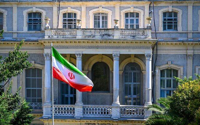 Un drapeau iranien flotte devant le consulat iranien, où des diplomates iraniens rencontrent leurs homologues allemands, britanniques et français pour de nouvelles négociations sur le nucléaire, à Istanbul, en Turquie, le 25 juillet 2025. (Crédit : Yasin AKGUL/AFP)