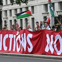 Des manifestants brandissent une banderole appelant à l'imposition de sanctions à Israël lors d'une manifestation de soutien aux Palestiniens de Gaza dans un contexte de craintes de famine dans le territoire en proie à la guerre, devant Downing Street, à Londres, le 29 juillet 2025. (JUSTIN TALLIS / AFP)