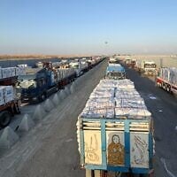 Des camions chargés d'aide humanitaire attendant du côté égyptien du point de passage de Rafah la permission d'entrer dans la bande de Gaza, le 3 août 2025. (Crédit : AFP)