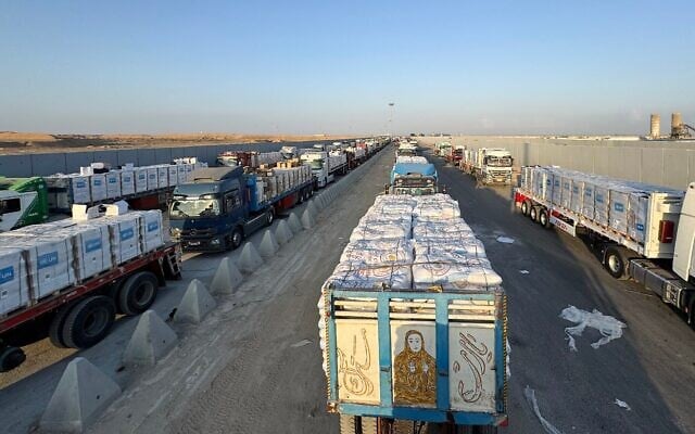 Des camions chargés d'aide humanitaire attendant du côté égyptien du point de passage de Rafah la permission d'entrer dans la bande de Gaza, le 3 août 2025. (Crédit : AFP)