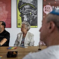 Des participants à une réunion pour les réfugiés juifs âgés d'Ukraine sont assis autour d'une table lors d'une réunion au siège du Centre communautaire juif à Varsovie, le 24 juillet 2025. (Crédit : Wojtek RADWANSKI / AFP)