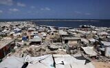 Des tentes servant d'abris temporaires aux Gazaouis déplacés installées autour de bâtiments endommagés par la guerre, le long de la plage de Gaza-City, le 8 août 2025. (Crédit : Bashar Taleb/AFP)