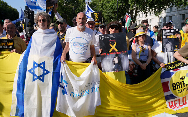 Des personnes brandissent des drapeaux et des pancartes lors d'une "Marche nationale pour les otages" organisée par Stop the Hate UK, dans le centre de Londres, le 10 août 2025. (Crédit : CARLOS JASSO / AFP) Des personnes brandissent des drapeaux et des pancartes lors d'une "Marche nationale pour les otages" organisée par Stop the Hate UK, dans le centre de Londres, le 10 août 2025. (Crédit : CARLOS JASSO / AFP)