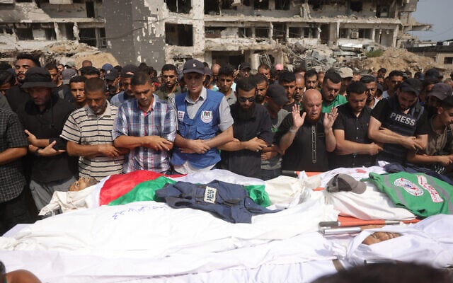 Des personnes en deuil prient lors de funérailles collectives pour des Palestiniens, dont des journalistes et un médecin, tués dans une frappe israélienne nocturne, devant l'hôpital Al-Shifa dans la ville de Gaza, le 11 août 2025. (BASHAR TALEB / AFP)