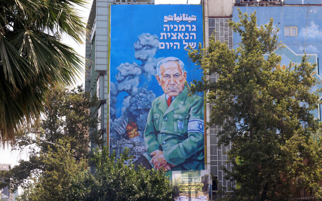 Cette photo montre un panneau d'affichage récemment dévoilé représentant le Premier ministre israélien Benjamin Netanyahu, avec le texte en persan « Hitanyahu » et le texte en hébreu « Le nazi allemand d'aujourd'hui » sur la place Palestine, dans le centre de Téhéran, le 11 août 2025. (Crédit : ATTA KENARE / AFP) Cette photo montre un panneau d'affichage récemment dévoilé représentant le Premier ministre israélien Benjamin Netanyahu, avec le texte en persan « Hitanyahu » et le texte en hébreu « Le nazi allemand d'aujourd'hui » sur la place Palestine, dans le centre de Téhéran, le 11 août 2025. (Crédit : ATTA KENARE / AFP)