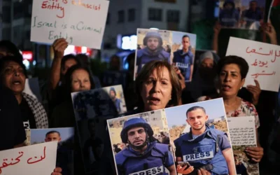 Des manifestants brandissant des photos et des pancartes dénonçant l’élimination du journalistes d'Al-Jazeera au service du Hamas, à Ramallah, le 11 août 2025. (Crédit : Zain Jaafar/AFP)