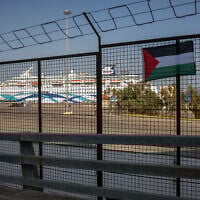 Un drapeau palestinien accroché par des manifestants sur une clôture du port du Pirée lors d'une manifestation contre l'arrivée du « Crown Iris » (à l'arrière-plan), un paquebot transportant des touristes israéliens à Athènes, le 14 août 2025. (Crédit : Angelos TZORTZINIS / AFP)