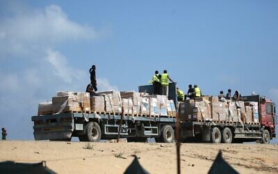 Un camion transportant de l'aide humanitaire roule sur une route de Deir al-Balah, dans le centre de la bande de Gaza, le 21 août 2025. (Crédit : Eyad BABA/AFP)