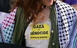Une femme portant un autocollant sur lequel on peut lire « Gaza = génocide, boycottez Israël » avant la cérémonie d'ouverture du 82ᵉ Festival du film de Venise, au Lido, à Venise, le 27 août 2025. (Crédit : Tiziana Fabi/AFP)