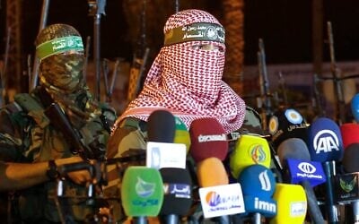 Abu Obeida (à droite), porte-parole de la branche armée du Hamas, les Brigades Ezzedine al-Qassam, faisant une déclaration, à Gaza, le 8 juillet 2015. (Crédit : Mohammed Abed/AFP) Abu Obeida (à droite), porte-parole de la branche armée du Hamas, les Brigades Ezzedine al-Qassam, faisant une déclaration, à Gaza, le 8 juillet 2015. (Crédit : Mohammed Abed/AFP)