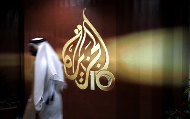 Illustration : un employé d'Al Jazeera passe devant le logo de la chaîne à son siège social à Doha, au Qatar, en 2016. (Crédit : AP/ Kamran Jebreili, Document) Illustration : un employé d'Al Jazeera passe devant le logo de la chaîne à son siège social à Doha, au Qatar, en 2016. (Crédit : AP/ Kamran Jebreili, Document)