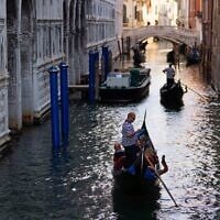 Des gondoliers emmènent des touristes au Ponte dei Sospiri (Pont des Soupirs), à Venise, en Italie, le 17 juin 2021. (Crédit : AP Photo/Luca Bruno)