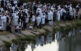 Des juifs orthodoxes prient près du lac, devant la tombe du rabbin Nachman, arrière-petit-fils du fondateur du mouvement hassidique, dans la ville d'Ouman, en Ukraine, le 3 octobre 2024. (Crédit : AP Photo/Efrem Lukatsky)