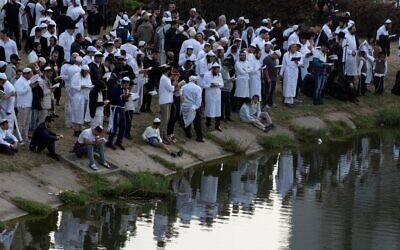 Des juifs orthodoxes prient près du lac, devant la tombe du rabbin Nachman, arrière-petit-fils du fondateur du mouvement hassidique, dans la ville d'Ouman, en Ukraine, le 3 octobre 2024. (Crédit : AP Photo/Efrem Lukatsky)