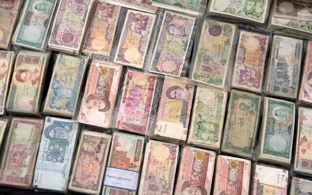 Des billets de banque iraniens actuels et d'avant la révolution sont exposés par un vendeur sur la place Ferdowsi, lieu incontournable pour le change de devises étrangères dans le centre-ville de Téhéran, en Iran, le 5 février 2025. (Crédit : AP Photo/Vahid Salemi)