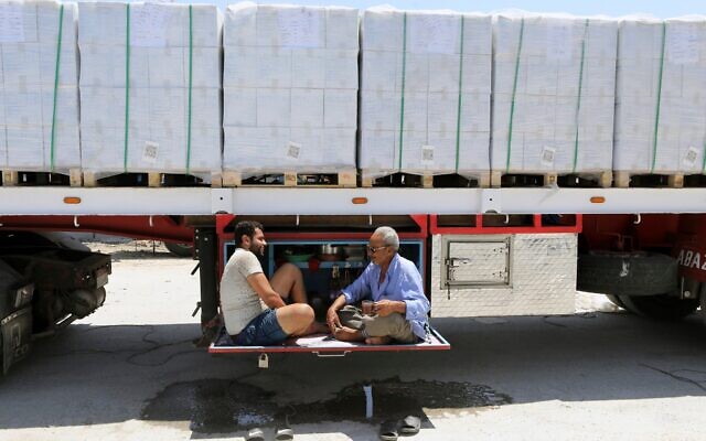 Des chauffeurs routiers transportant de l'aide humanitaire, buvant du thé en attendant de traverser le point de passage de Rafah, entre l'Égypte et la bande de Gaza, le 6 août 2025. (Crédit : Khaled Elfiqi/AP) Des chauffeurs routiers transportant de l'aide humanitaire, buvant du thé en attendant de traverser le point de passage de Rafah, entre l'Égypte et la bande de Gaza, le 6 août 2025. (Crédit : Khaled Elfiqi/AP)