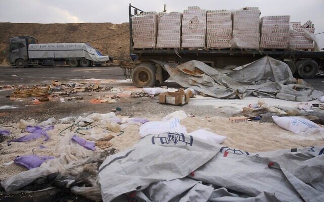 Des camions endommagés transportant de l’aide humanitaire destinée aux Palestiniens de Gaza sont stationnés près de la frontière avec la bande de Gaza, à proximité du point de passage de Kissufim, dans le sud d’Israël, le 13 août 2025. (Crédit : Ariel Schalit/AP)
