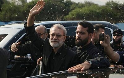 Ali Larijani (au centre) chef du Conseil national de sécurité iranien, saluant les partisans du Hezbollah qui lui lancent du riz pour l'accueillir à l'extérieur de l'aéroport international Rafik Hariri de Beyrouth, au Liban, le 13 août 2025. (Crédit : Bilal Hussein/AP)