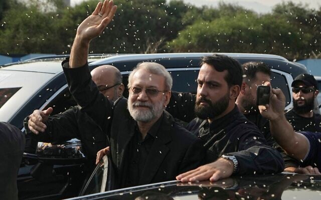 Ali Larijani (au centre) chef du Conseil national de sécurité iranien, saluant les partisans du Hezbollah qui lui lancent du riz pour l'accueillir à l'extérieur de l'aéroport international Rafik Hariri de Beyrouth, au Liban, le 13 août 2025. (Crédit : Bilal Hussein/AP) Ali Larijani (au centre) chef du Conseil national de sécurité iranien, saluant les partisans du Hezbollah qui lui lancent du riz pour l'accueillir à l'extérieur de l'aéroport international Rafik Hariri de Beyrouth, au Liban, le 13 août 2025. (Crédit : Bilal Hussein/AP)