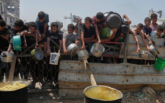 Des Palestiniens se battent pour obtenir de la nourriture distribuée dans une cuisine communautaire à Gaza, dans le nord de la bande de Gaza, le 16 août 2025. (Crédit : AP Photo/Jehad Alshrafi)