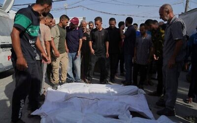 Des Palestiniens se tiennent à côté des corps de leurs proches, tués lors d'une frappe aérienne israélienne, devant l'hôpital Al-Aqsa à Deir al-Balah, le 19 août 2025. (Crédit : AP Photo/Abdel Kareem Hana) Des Palestiniens se tiennent à côté des corps de leurs proches, tués lors d'une frappe aérienne israélienne, devant l'hôpital Al-Aqsa à Deir al-Balah, le 19 août 2025. (Crédit : AP Photo/Abdel Kareem Hana)