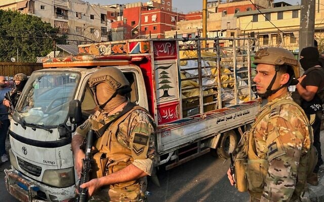 Des soldats des forces armées libanaises (LAF) se tenant à côté d'une camionnette transportant des armes remises par des factions palestiniennes dans le camp de réfugiés palestiniens de Burj al-Barajneh à Beyrouth, au Liban, le 21 août 2025. (Crédit : Hussein Malla/AP) Des soldats des forces armées libanaises (LAF) se tenant à côté d'une camionnette transportant des armes remises par des factions palestiniennes dans le camp de réfugiés palestiniens de Burj al-Barajneh à Beyrouth, au Liban, le 21 août 2025. (Crédit : Hussein Malla/AP)