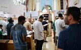 Des Juifs pratiquants rassemblés à la veille de Tisha Beav dans une synagogue de Tel Aviv pour la lecture annuelle du Livre des Lamentations, le 12 août 2024. (Crédit : Tomer Neuberg/Flash90)