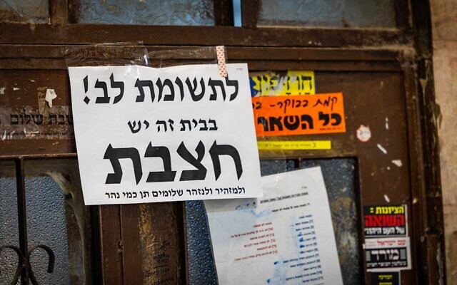 Une affiche avertissant de la rougeole sur une porte, dans le quartier ultra-orthodoxe de Mea Shearim, à Jérusalem, le 31 juillet 2025. (Crédit : Chaïm Goldberg/Flash90)