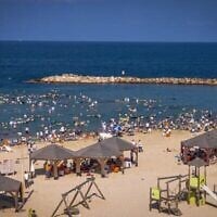 En pleine canicule, des centaines d'hommes et enfants ultra-orthodoxes profitent de la mer sur la plage religieuse de Tel Aviv, le 8 août 2025. (Crédit : Flash90)