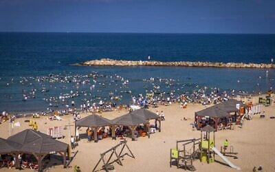 En pleine canicule, des centaines d'hommes et enfants ultra-orthodoxes profitent de la mer sur la plage religieuse de Tel Aviv, le 8 août 2025. (Crédit : Flash90)