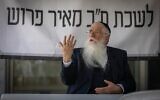 Le député Meir Porush devant une banderole sur laquelle on peut lire « Bureau du député Meir Porush », lors d'une manifestation devant le ministère de la Justice à Jérusalem, le 7 août 2025. (Crédit : Chaim Goldberg/Flash90)