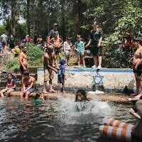 Des Israéliens se rafraîchissent dans un bassin naturel dans les hauteurs du Golan, le 12 août 2025. (Crédit : Michael Giladi/ Flash90)