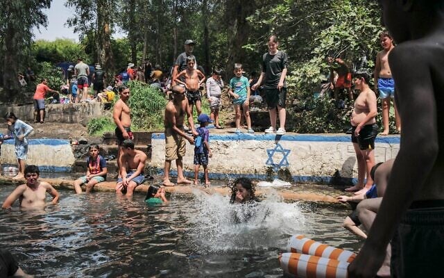 Des Israéliens se rafraîchissent dans un bassin naturel dans les hauteurs du Golan, le 12 août 2025. (Crédit : Michael Giladi/ Flash90)