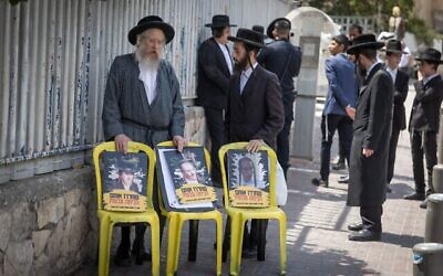 Des juifs ultra-orthodoxes manifestant devant des bureaux de recrutement de l'armée à Jérusalem, le 13 août 2025. Sur leurs affiches, qui s'inspirent du modèle de celles des otages du Hamas, on voit des photos de déserteurs arrêtés assortis d'un texte appelant à leur libération. (Crédit : Chaïm Goldberg/Flash90) Des juifs ultra-orthodoxes manifestant devant des bureaux de recrutement de l'armée à Jérusalem, le 13 août 2025. Sur leurs affiches, qui s'inspirent du modèle de celles des otages du Hamas, on voit des photos de déserteurs arrêtés assortis d'un texte appelant à leur libération. (Crédit : Chaïm Goldberg/Flash90)