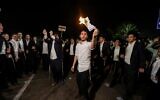Des manifestants ultra-orthodoxes brûlent des ordres d'enrôlement lors d'une manifestation devant la prison militaire de Beit Lid, le 14 août 2025. (Crédit : Tal Gal/Flash90)