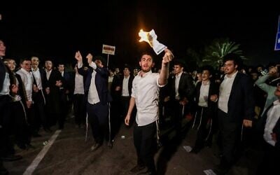 Des manifestants ultra-orthodoxes brûlant des ordres d'enrôlement lors d'une manifestation devant la prison militaire de Beit Lid, le 14 août 2025. (Crédit : Tal Gal/Flash90)