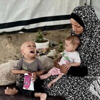 Abdulla Abu Zarka (à gauche), un enfant qui souffrirait de malnutrition à Gaza, avec sa mère et son frère, sur une photo diffusée en ligne en juillet 2025. (Crédit : X ; utilisé conformément à la clause 27a de la loi sur le droit d'auteur)