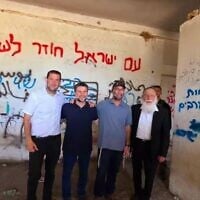 Le ministre Bezalel Smotrich (2ᵉ depuis la gauche) photographié devant un mur couvert de graffitis, dont l’un proclamant “Mort aux Arabes”. À sa gauche : Yossi Dagan, chef du Conseil régional de Samarie, à Sa-Nur, le 6 août 2025.
(Crédit : Capture d'écran/X/Roi Hadi / Conseil régional de Samarie; utilisée conformément à la clause 27a de la loi sur le droit d'auteur)