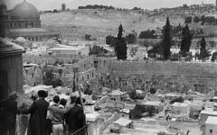 Un groupe de Juifs se tenant sur un balcon surplombant le quartier marocain et le mur Occidental, avec le Dôme du Rocher au loin derrière eux, prise entre 1920 et 1933. (Crédit : Bibliothèque du Congrès, division des estampes et photographies)