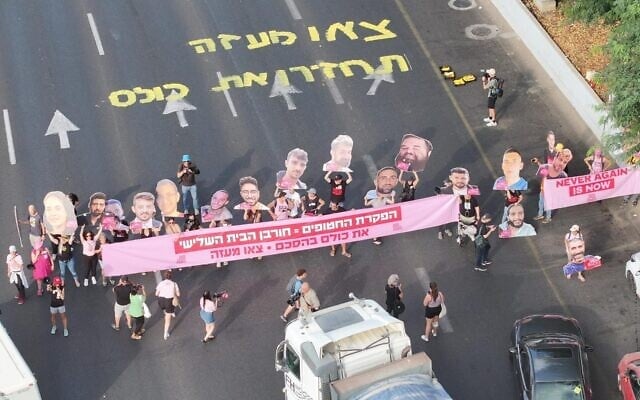 Des manifestants réclamant un accord pour la libération des otages à Gaza bloquant l'autoroute Ayalon et brandissant une banderole sur laquelle on peut lire « Abandonner les otages = destruction du Troisième Temple. Ramenez-les à la maison. Sortez de Gaza », à Tel Aviv, le 3 août 2025. (Crédit : Aviv Atlas/Mouvement de protestation pour la démocratie)