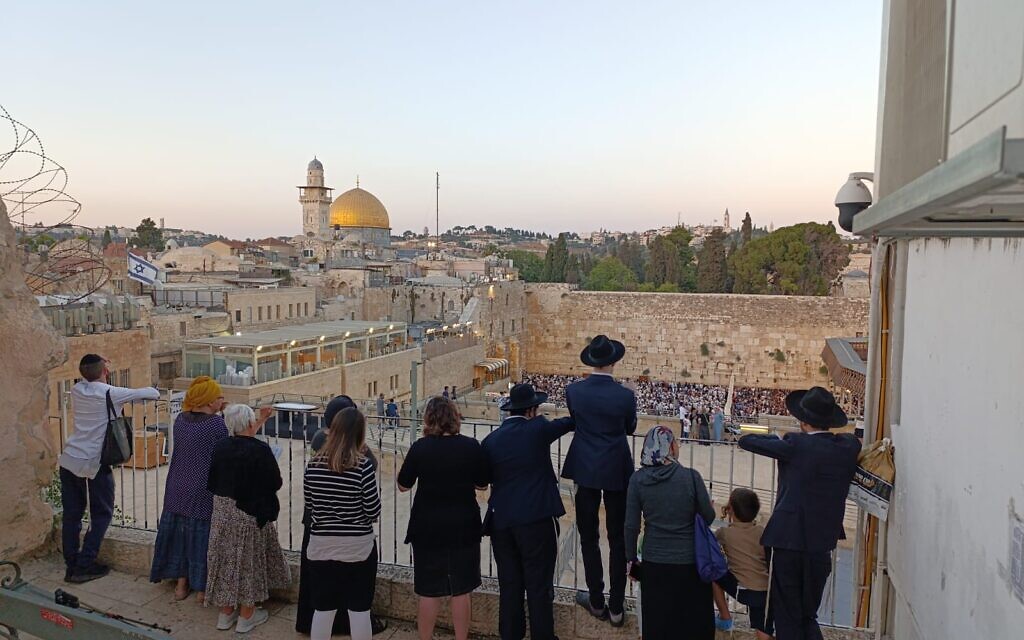 Des visiteurs regardent le Mur occidental le jour de Tisha B'Av, le 3 août 2025 (Crédit : Zev Stub/Times of Israel)