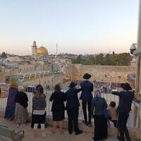 Des visiteurs regardent le Mur occidental le jour de Tisha B'Av, le 3 août 2025 (Crédit : Zev Stub/Times of Israel)