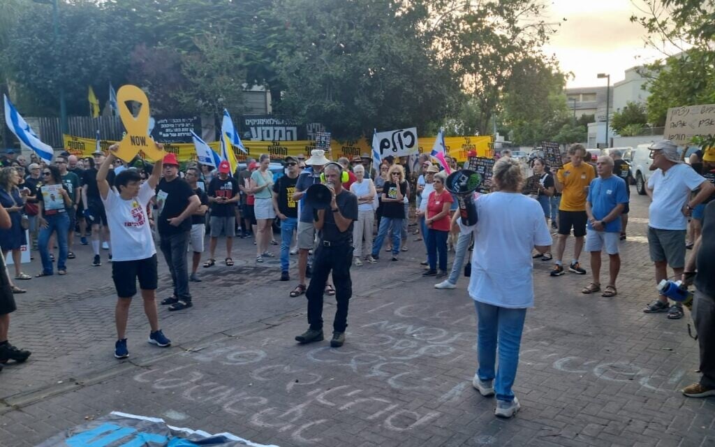 Des manifestants réclamant un accord pour libérer les otages et mettre fin à la guerre à Gaza devant le domicile du ministre de l'Éducation, Yoav Kisch, à Hod HaSharon, le 26 août 2025. (Crédit : Ilan Faigenbaum/Mouvement de protestation pour la démocratie)