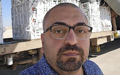 Ahmed Fouad Alkhatib pose à côté d'un avion prêt à larguer de l'aide à Gaza, dans une publication sur X depuis Amman, en Jordanie, le 25 août 2025. (Crédit : Autorisation)