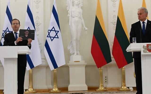Le président Isaac Herzog brandit une photo de l'otage Rom Braslavski alors qu'il s'exprime aux côtés du président lituanien Gitanas Nausėda, à Vilnius, le 4 août 2025. (Crédit : Omer Meron/GPO)